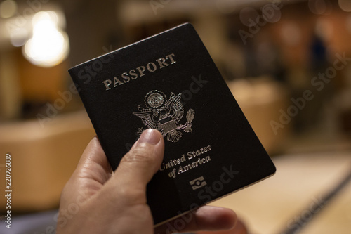 hand holding passport with bokeh background, jorney and travel concept.