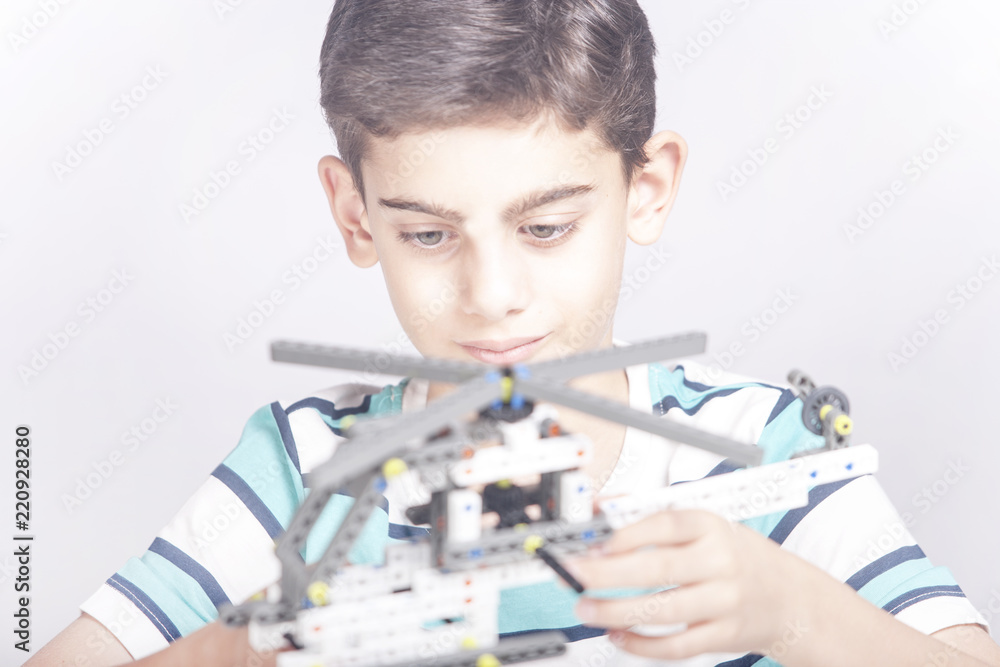 Boy creates a diy mechanical helicopter model. STEM education concept Boy creates a diy mechanical helicopter model. STEM education concept