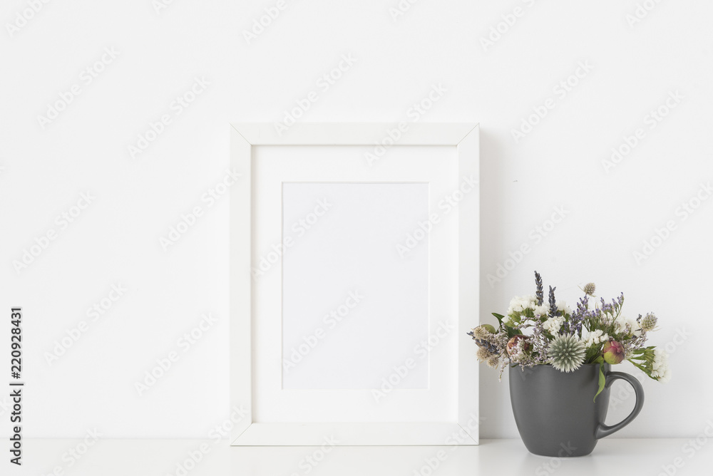 Molern white a5 portrait frame mockup with dried field wild flowers in mug on white wall background. Empty frame, poster mock up for presentation design. Molern white a5 portrait frame mockup with dried field wild flowers in mug on white wall background. Empty frame, poster mock up for presentation design.
