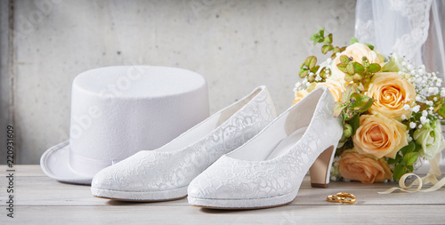 Wedding shoes next to flower bouquet and hat