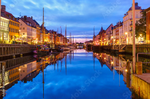 Panorama of Nyhavn with colorful facades of old houses and old ships in the Old Town of Copenhagen, capital of Denmark.