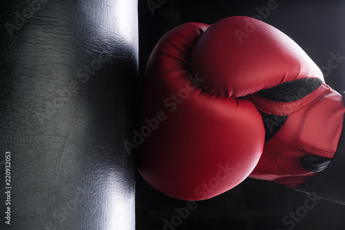 Tough man hitting punching bag with boxing glove.
