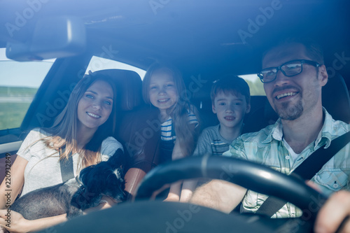 family with two children traveling in a family car © ASDF