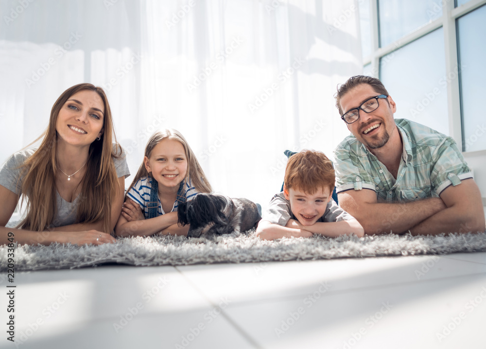 Happy family lying on carpet in room at new home Happy family lying on carpet in room at new home