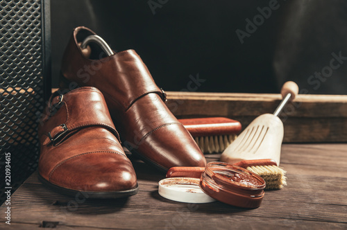 Leather shoes and shoe polish equipment on a wooden composition