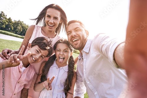 Beautiful memories. Family of four taking selfie photo on smartp