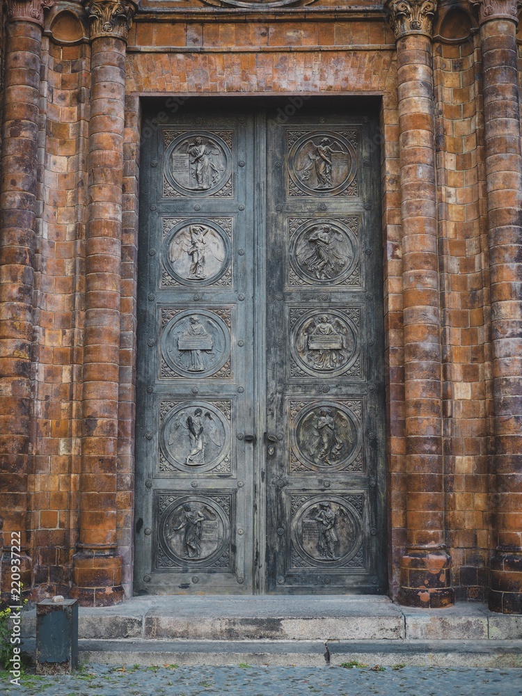 Vintage old painted metal door of the brick cathedral