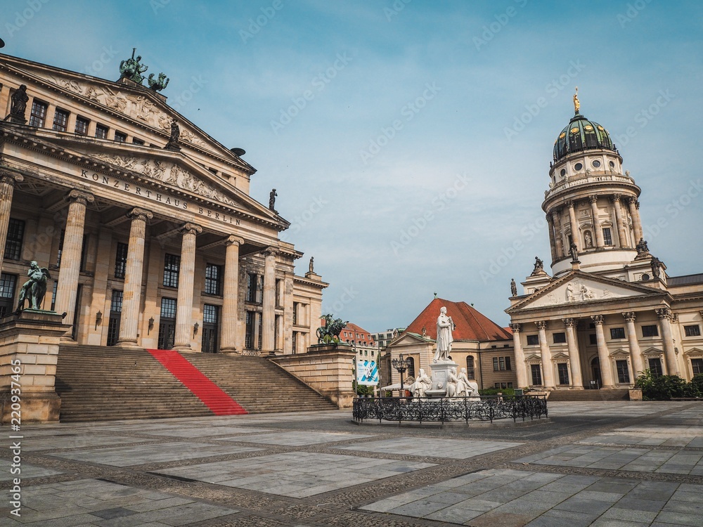 The concert hall with statues and the red carpet is located on the square in Berlin