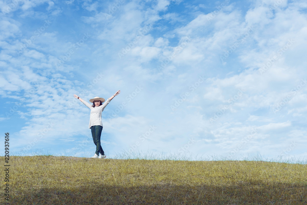 Standing woman raised her hands on the mountain, natural green and beautiful sky. Standing woman raised her hands on the mountain, natural green and beautiful sky.