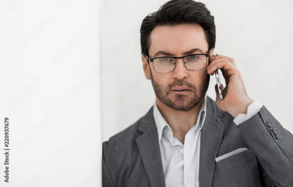 close up.serious businessman leaning on the wall close up.serious businessman leaning on the wall