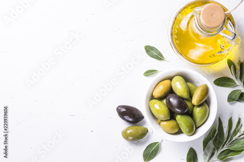 Olives and olive oil on white. photo