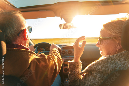 Elderly loving couple traveling in car on vacation.