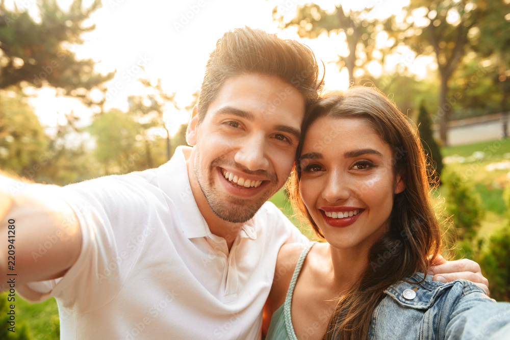 Loving couple walking outdoors while make a selfie by camera. Loving couple walking outdoors while make a selfie by camera.