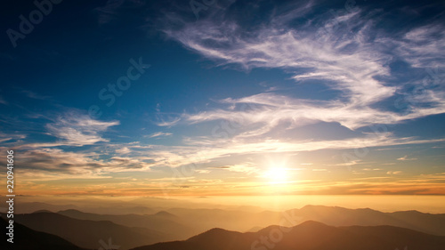 Silhouettes of mountains on background of sunset sky