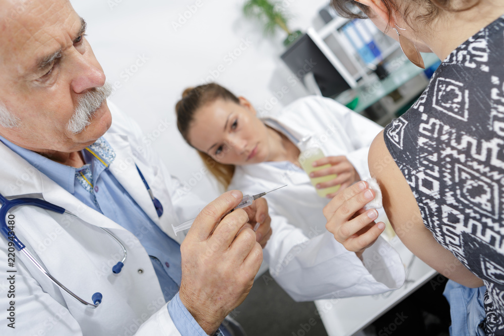 Obraz premium senior doctor injecting patient with syringe