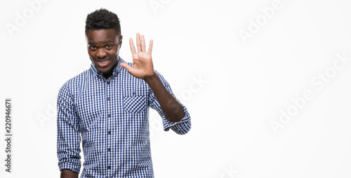 Young african american man wearing blue shirt showing and pointing up with fingers number five while smiling confident and happy.