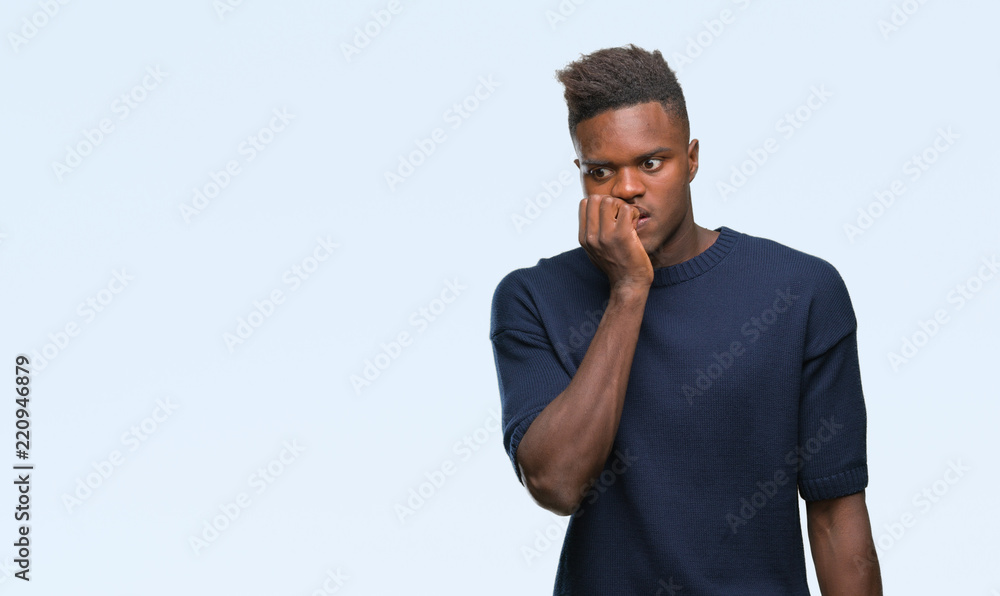 Young african american man over isolated background looking stressed and nervous with hands on mouth biting nails. Anxiety problem. Young african american man over isolated background looking stressed and nervous with hands on mouth biting nails. Anxiety problem.