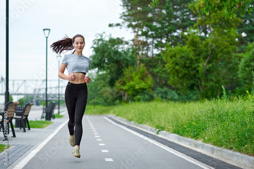 Running asian woman on the waterfront. Morning jogging. The athlete trains © Joe-L
