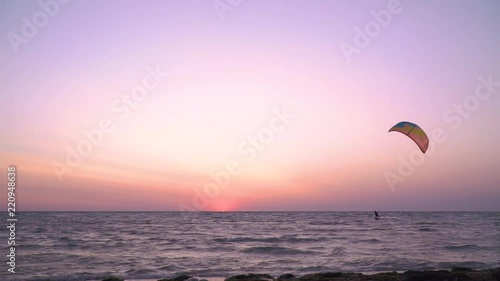 A man controls a training kite, alone kitesurfer at dawn, slow motion