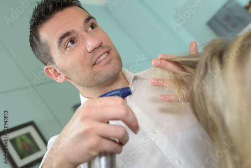 Hairdresser spraying water on customer's hair