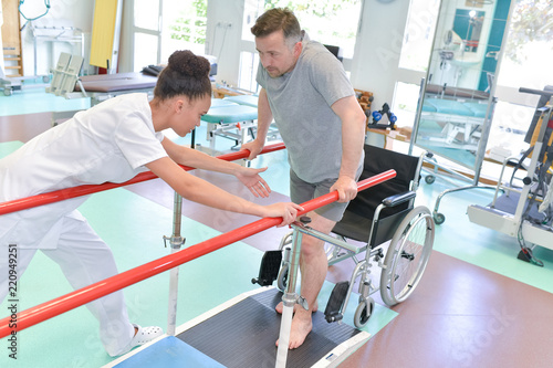 nurse assisting man to walk using walker