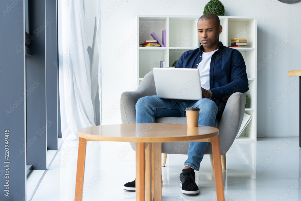 Image of african american businessman working on his laptop. Handsome young man at his desk Image of african american businessman working on his laptop. Handsome young man at his desk