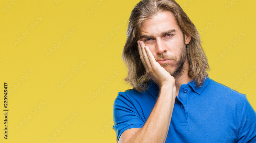 Young handsome man with long hair over isolated background thinking looking tired and bored with depression problems with crossed arms. Young handsome man with long hair over isolated background thinking looking tired and bored with depression problems with crossed arms.