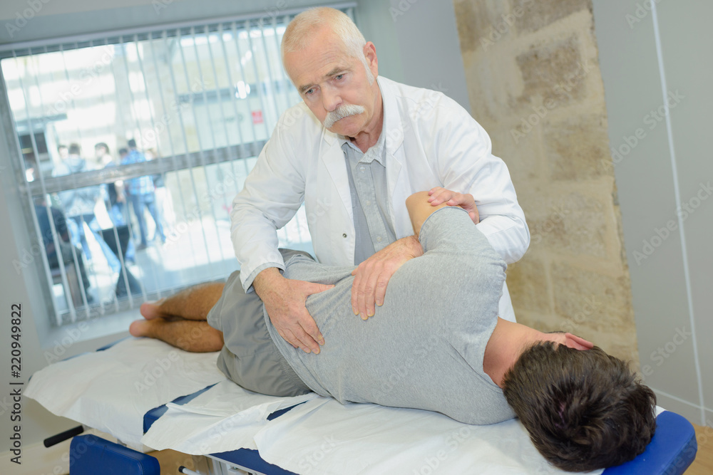 Fototapeta premium senior physiotherapist working with patient in clinic