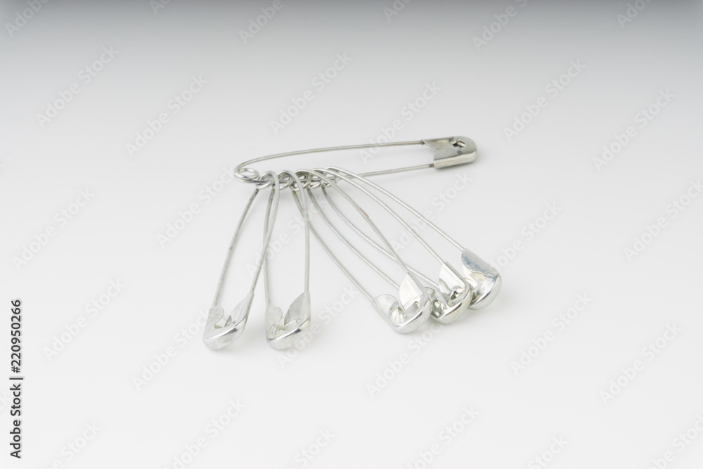Safety pin isolated on a white background with selective focus and crop fragment Safety pin isolated on a white background with selective focus and crop fragment