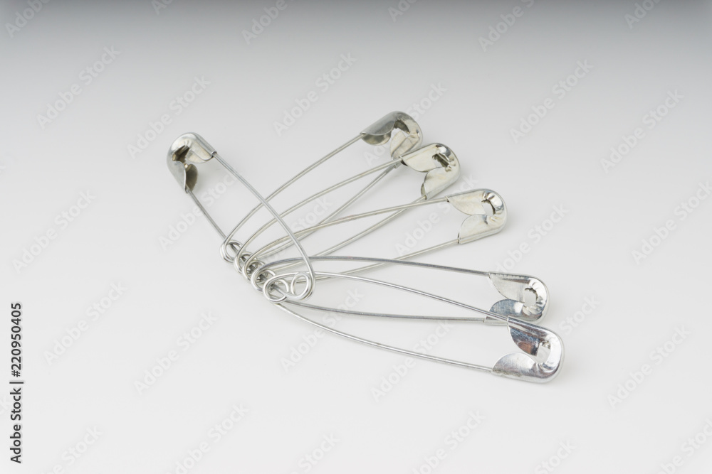Safety pin isolated on a white background with selective focus and crop fragment Safety pin isolated on a white background with selective focus and crop fragment