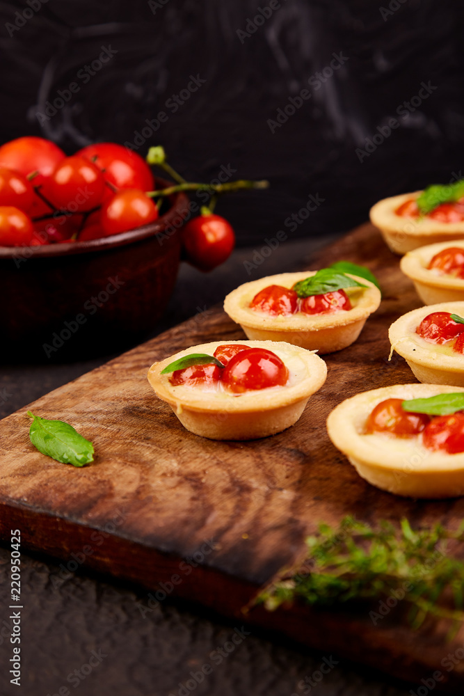 Mini tarts with cherry tomatoes with mozzarella cheese