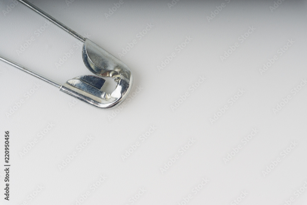 Safety pin isolated on a white background with selective focus and crop fragment Safety pin isolated on a white background with selective focus and crop fragment