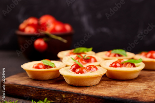Mini tarts with cherry tomatoes with mozzarella cheese