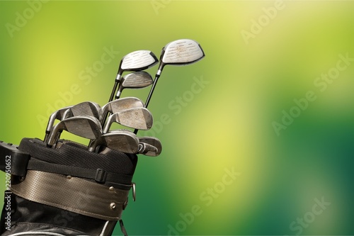 Different golf clubs on background.