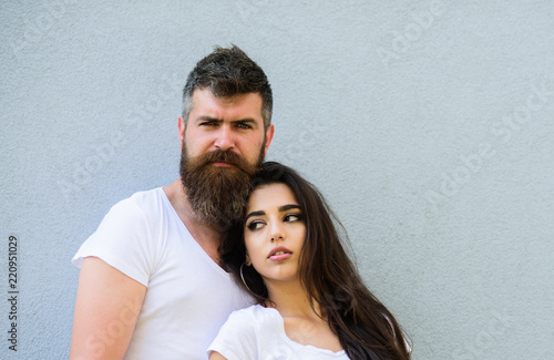 Couple stylish young modern people. Urban loving couple. Couple white shirts lean each other. Hipster bearded and stylish girl hang out outdoors. Couple in love hang out together grey wall background