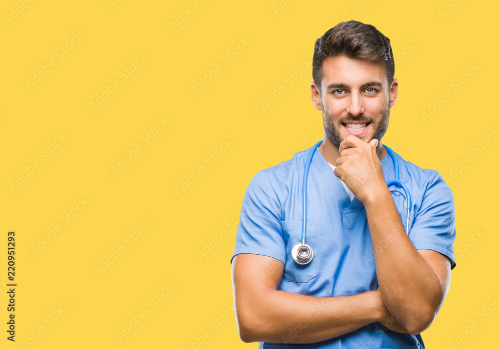 Young handsome doctor surgeon man over isolated background looking confident at the camera with smile with crossed arms and hand raised on chin. Thinking positive. Young handsome doctor surgeon man over isolated background looking confident at the camera with smile with crossed arms and hand raised on chin. Thinking positive.