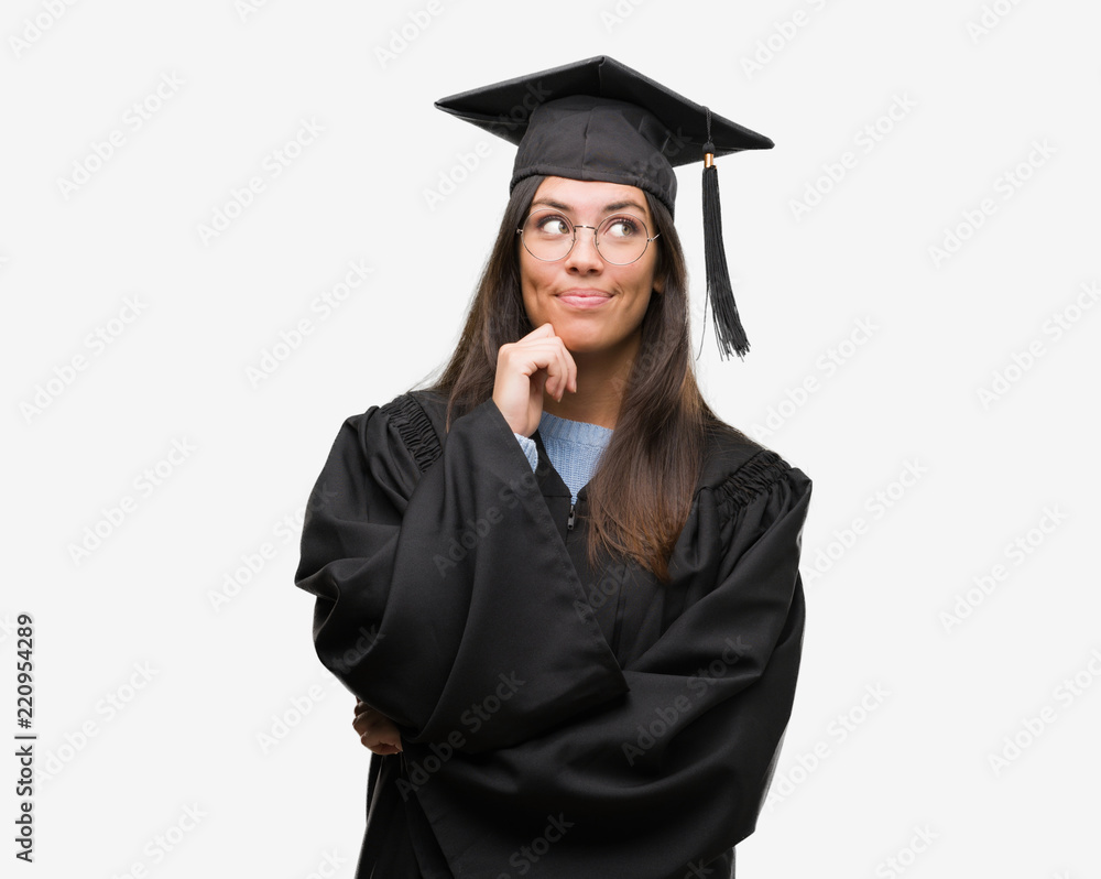 Young hispanic woman wearing graduated cap and uniform with hand on chin thinking about question, pensive expression. Smiling with thoughtful face. Doubt concept. Young hispanic woman wearing graduated cap and uniform with hand on chin thinking about question, pensive expression. Smiling with thoughtful face. Doubt concept.