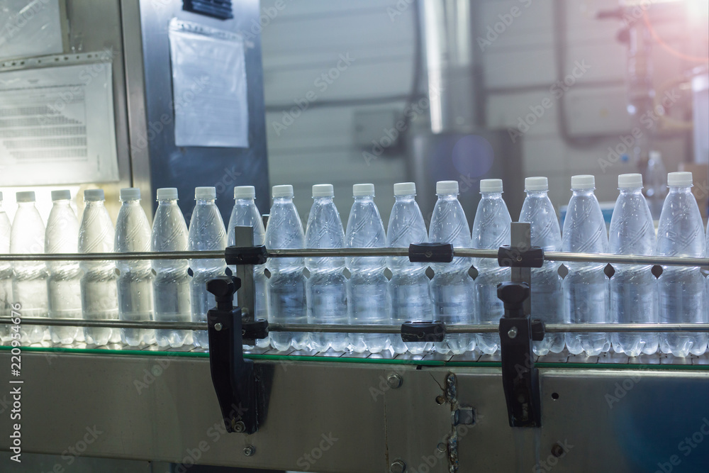 Water bottles on production line. Bottling mineral water into small bottles