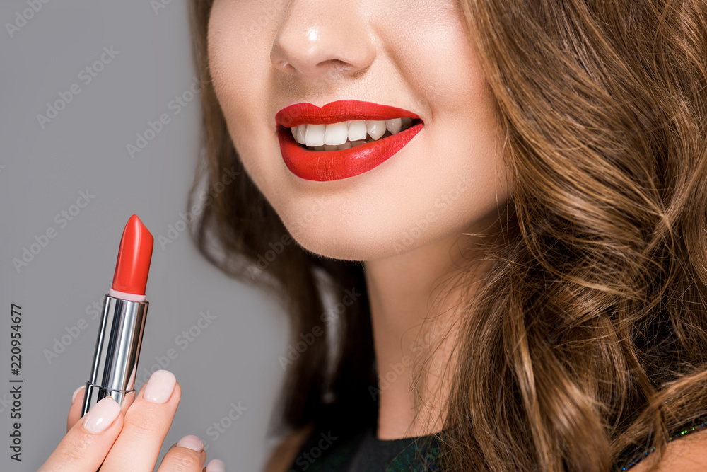 partial view of smiling woman with red lipstick isolated on grey partial view of smiling woman with red lipstick isolated on grey