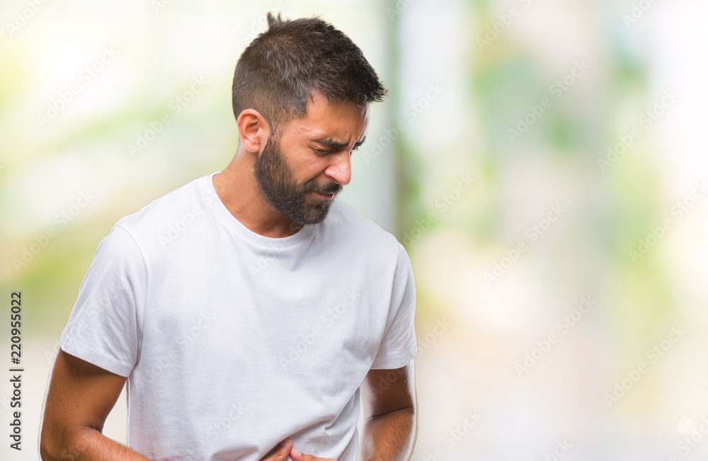 Adult hispanic man over isolated background with hand on stomach because nausea, painful disease feeling unwell. Ache concept. Adult hispanic man over isolated background with hand on stomach because nausea, painful disease feeling unwell. Ache concept.