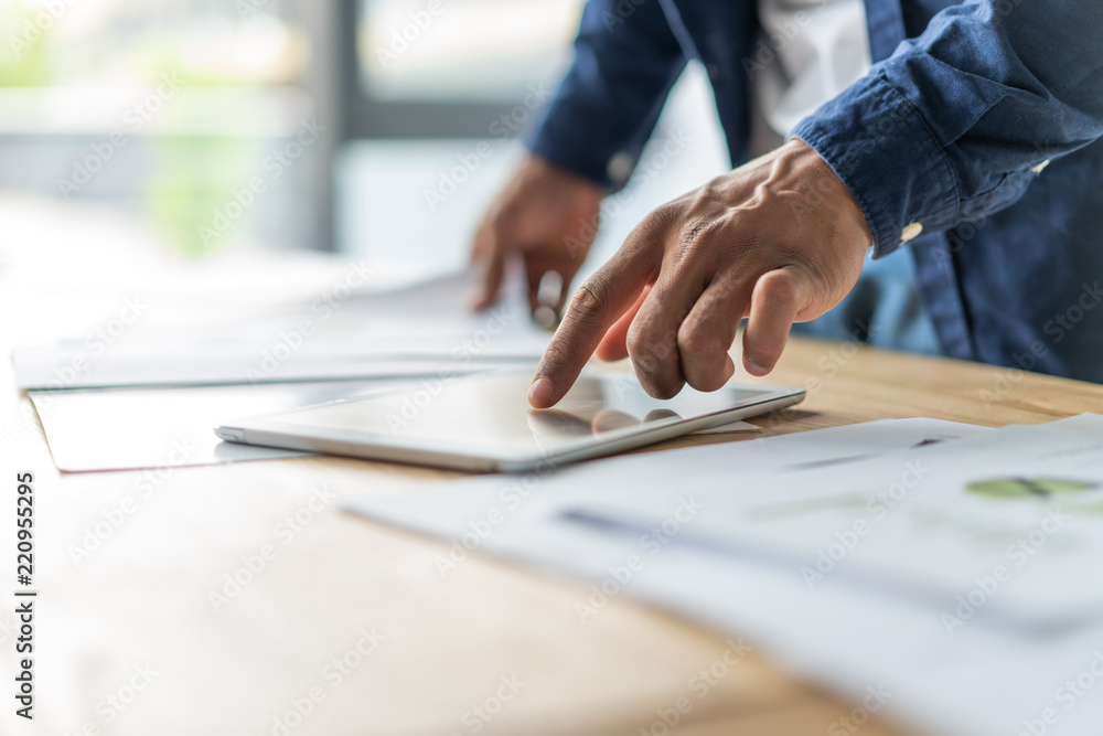 Hands of an African businessman using digital tablet in office. Hands of an African businessman using digital tablet in office.