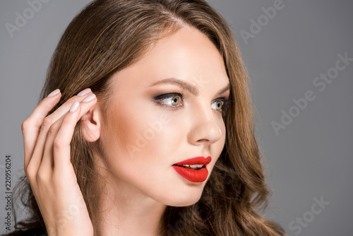 portrait of young stylish woman with red lipstick on lips isolated on grey