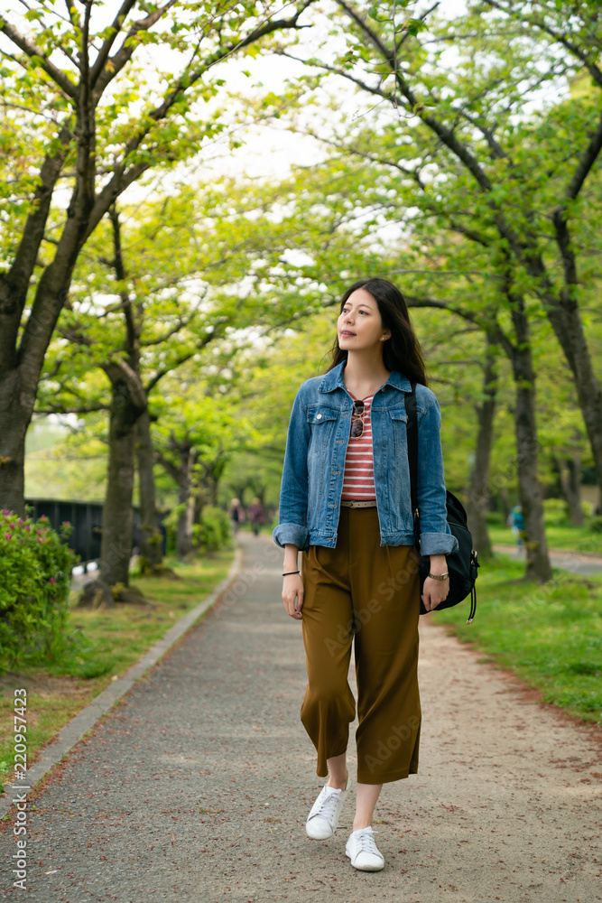 travel woman walking in the pathway of park travel woman walking in the pathway of park