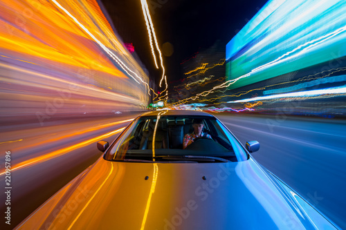 View from Front of Car moving in a night city, Blured road with lights with car on high speed. photo
