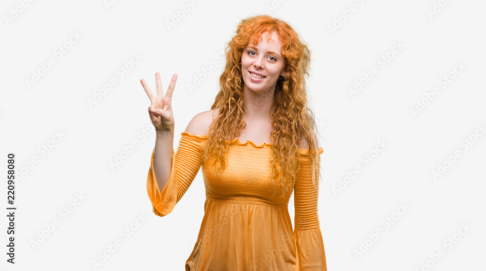 Young redhead woman showing and pointing up with fingers number three while smiling confident and happy. Young redhead woman showing and pointing up with fingers number three while smiling confident and happy.