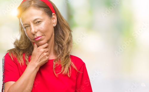 Middle age senior hispanic woman over isolated background looking confident at the camera with smile with crossed arms and hand raised on chin. Thinking positive.