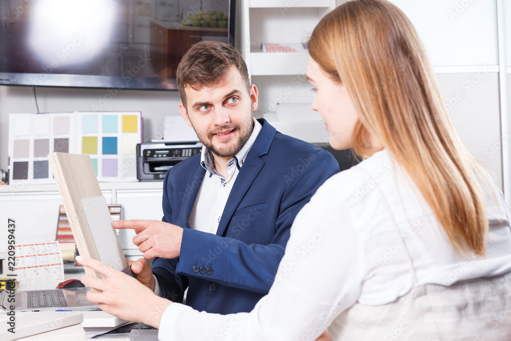 Obraz premium Girl consulting with salesman in furniture salon