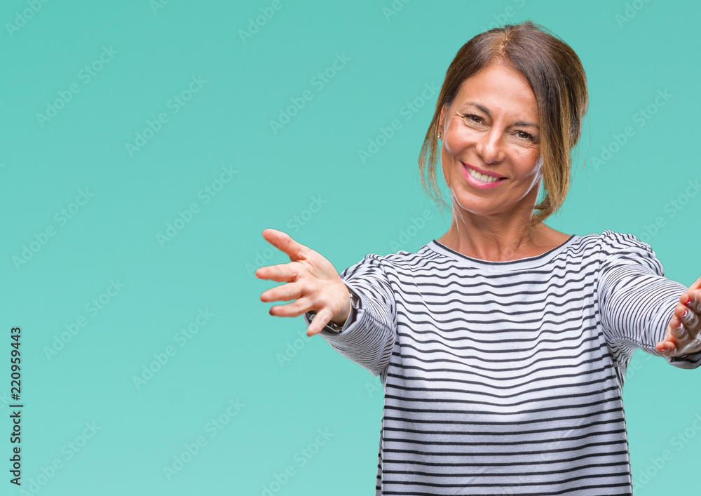 Middle age senior hispanic woman over isolated background looking at the camera smiling with open arms for hug. Cheerful expression embracing happiness. Middle age senior hispanic woman over isolated background looking at the camera smiling with open arms for hug. Cheerful expression embracing happiness.