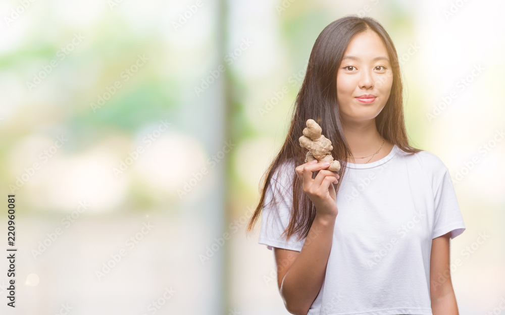 Young asian woman holding fresh organic over isolated background with a confident expression on smart face thinking serious