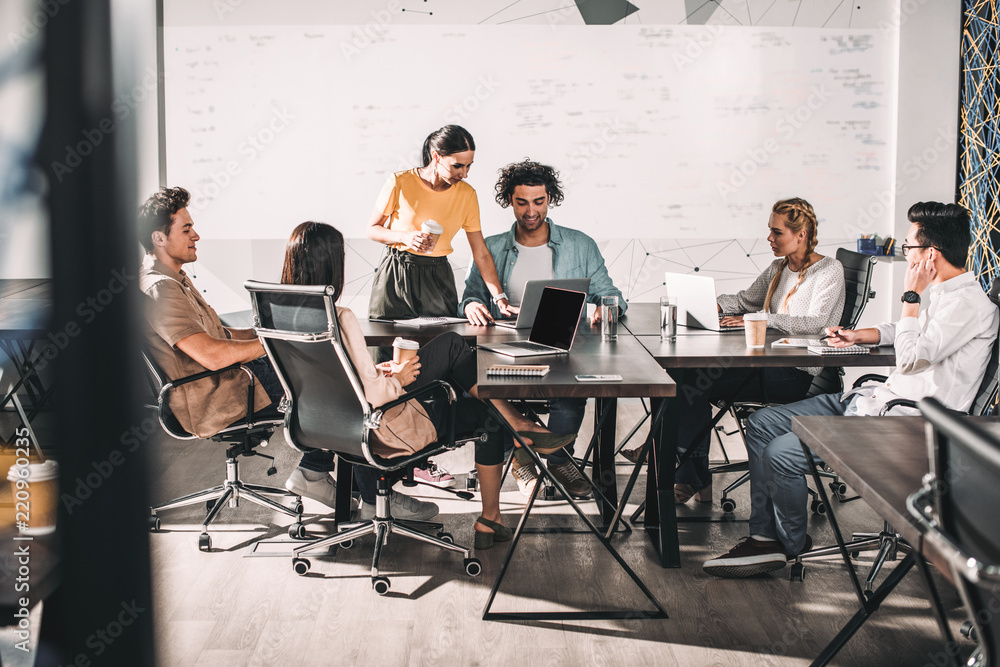 multiethnic business partners having meeting at table with laptops in modern office multiethnic business partners having meeting at table with laptops in modern office